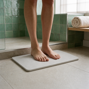 Bare feet standing on the Morven Cairn stone bath mat in a bathroom