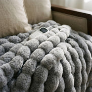 Close view of the Morven Wrap heated throw's faux fur texture with its controller