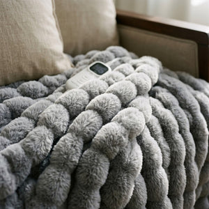 Close view of the Morven Wrap heated throw's faux fur texture with its controller