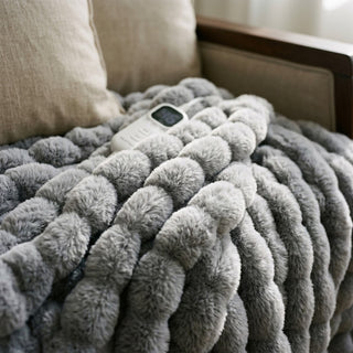 Close view of the Morven Wrap heated throw's faux fur texture with its controller