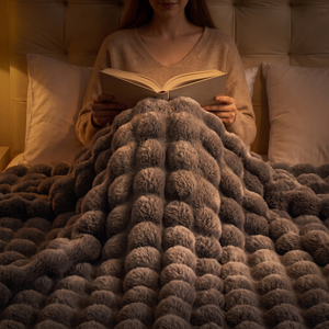 Woman reading in bed at night under the Morven Wrap heated throw